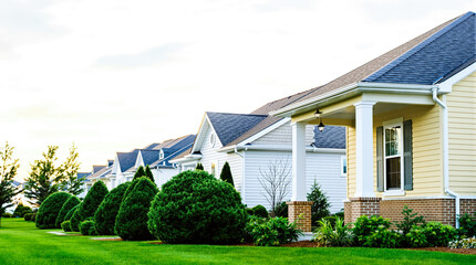 Obraz premium row of charming pastel-colored houses with manicured lawns and shrubs in a peaceful suburban neighborhood