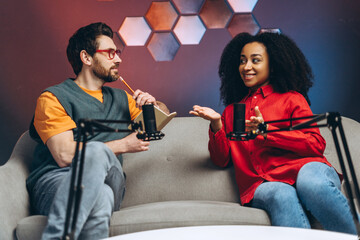 Radio hosts recording podcast in studio with microphones