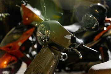 a classic scooter parked under the city lights at night. The gleaming chrome details and the iconic...