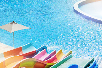 Water park with water colored flights, slides, splashes and pools at luxury hotel. summer vacation...