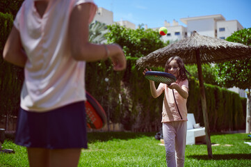 Children Playing Paddle Tennis Outdoors in Bright Summer Weather
