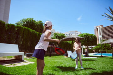 Obraz premium Outdoor Weekend Fun with Kids Playing Paddle Tennis in Park