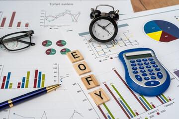 focus wooden blocks EOFY End of Financial Year with pen calculator and business diagraph paperwork