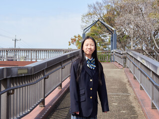 春の桜満開の公園で遊ぶ元気な女子中学生の姿