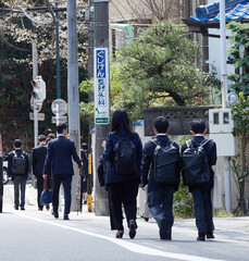 春の入学式に参加する学生と保護者たちの後ろ姿