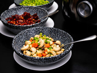 close-up of sauteed mushrooms with carrots and celery in a speckled bowl