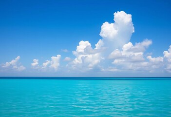 Obraz premium Serene blue sky, fluffy white clouds drift over calm turquoise sea, summer, horizon
