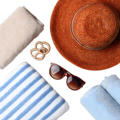 Vacation essentials: hat, towels, sunglasses, decorative knot on black backdrop.