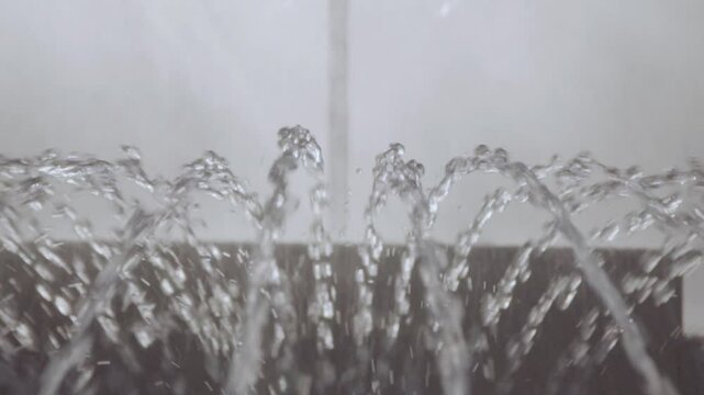 Close-up of moving fountain jets in slow motion in summer.