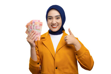 Cheerful young Asian woman holding money and giving thumbs up isolated on transparent background