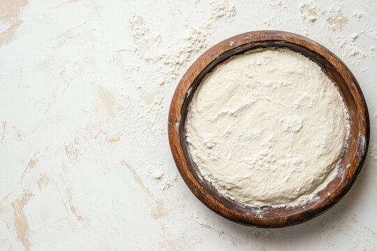 Bowl of white flour on surface.