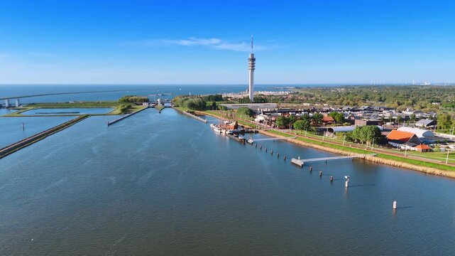 Marina surrounded by the dikes on the Markermmer lake, Lelystad,the Netherlands. Aerial view on the Museum Batavialand and telecom tower.