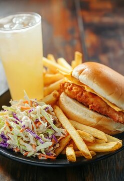 A fast food meal combo with a side of coleslaw, fries, and a refreshing lemonade.