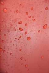 Close-up of water droplets on a vibrant red surface.