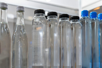 Row of plastic transparent water bottles close-up