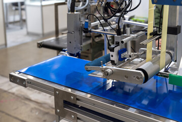 Automated labeling line with mechanical rollers and sensors close-up