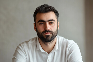Fototapeta premium Man with beard in white shirt serious expression neutral background