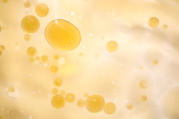 Yellow Oil Droplets Floating on Light Background with Soft Highlights