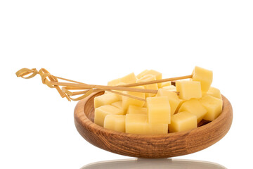 Fragrant hard cheese, cut into cubes in a wooden plate, isolated on a white background, macro.