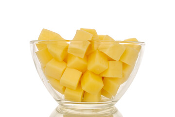 Fragrant hard cheese cut into cubes in a glass plate isolated on a white background, macro.