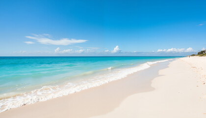 Serene beach with turquoise waves and white sand under clear sky  