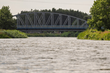 Fototapeta premium A bridge spans a river, with trees on either side