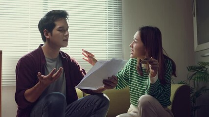 Worried couple arguing about their financial problems while checking their domestic bills at home - Powered by Adobe