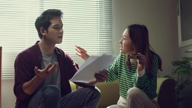 Worried couple arguing about their financial problems while checking their domestic bills at home