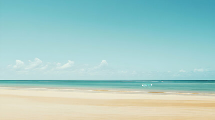 Fototapeta premium Sandy beach meets turquoise ocean under a clear blue sky.
