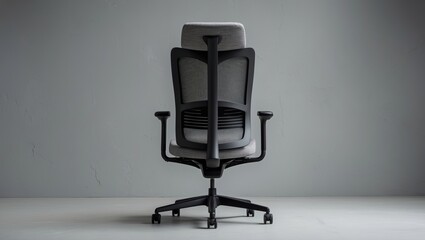Stylish office chair with a minimalist design, showcasing an ergonomic black mesh backrest and gray seat on a textured gray wall background