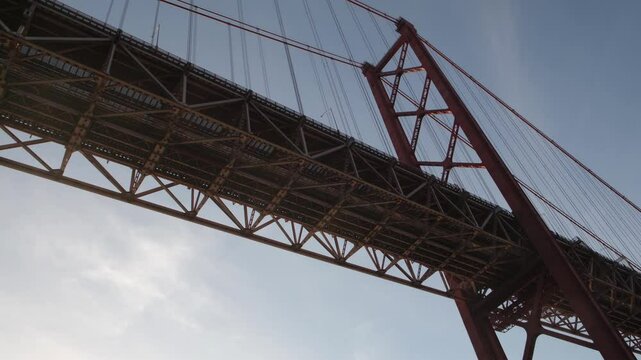 Airplane flying over the 25 de abril bridge, a suspension bridge connecting the city of lisbon, capital of portugal, to the municipality of almada on the left bank of the tagus river
