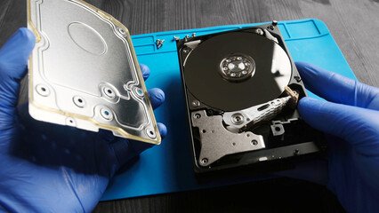 repairman opens computer hard disk drive to fix in service center