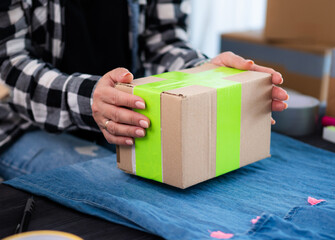 Girl Preparing Cardboard Box For Shipping