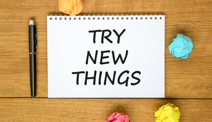 Try new things symbol. Concept words Try new things on beautiful white note. Black pen. Colored paper. Beautiful wooden background. Business motivational lifestyle try new things concept. Copy space.