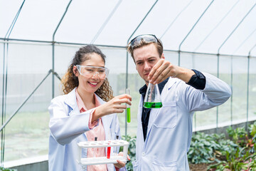 Scientist holding test tubes in organic farmland. Chemist working in organic farm.
