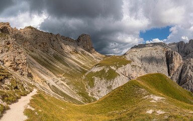 Naklejka premium Scenic view of rugged mountain landscape with dramatic clouds in the Dolomites, Italy