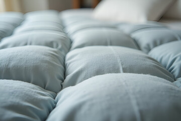 Fototapeta premium Soft quilted comforter in light blue used for bedroom comfort and decor.