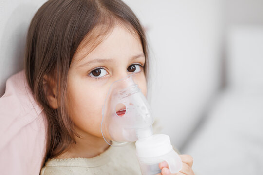 child is sick in bed. inhalation at home. Mom gives medicine to her daughter. Concept disease, pharmaceutics.