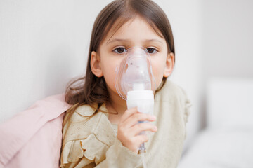 child is sick in bed. inhalation at home. Mom gives medicine to her daughter. Concept disease, pharmaceutics.