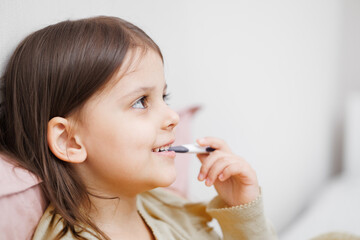 child is sick in bed. little girl measures body temperature. Concept disease, pharmaceutics.