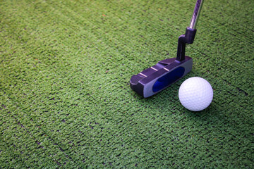 Obraz premium Close-Up of Golf Putter and Ball on Artificial Turf Surface