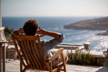 A man relaxing in a chair, enjoying a beautiful ocean view on a bright sunny day.