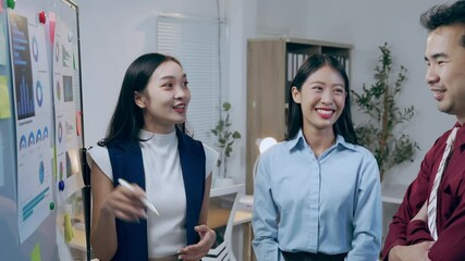 Diverse business team collaborating, analyzing financial data through charts and graphs on whiteboard, strategizing corporate project goals with focused teamwork in modern office environment