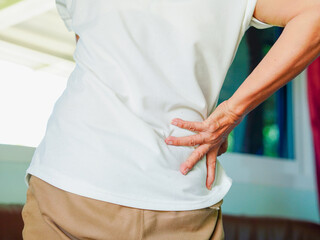 Asian senior woman holding waist with pain from work, back pain. Backache in the elderly mature. Illness, health care and healthy lifestyle. Senior female painful office syndrome 
