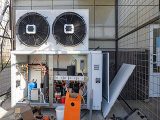 External conditioner unit on electrical cabinet. Ventilation communications building. Nitrogen tanks under conditioner. Supply ventilation pump on wall building. HVAC equipment. Split system repair
