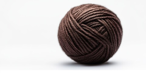 Close-up of a brown ball of yarn on white background