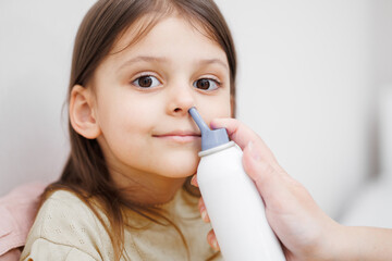 child is sick in bed. Mom gives medicine to her daughter. Mom drips her daughter's nose. Concept disease, pharmaceutics.