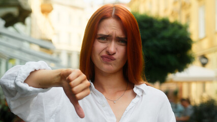 Caucasian woman girl outdoors showing thumb down refusal dissatisfied female businesswoman student...