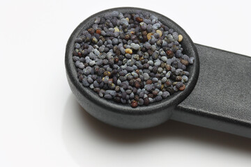 Poppy Seeds in spoon on white pile