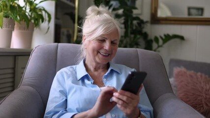 Senior woman using mobile phone at home
 - Powered by Adobe